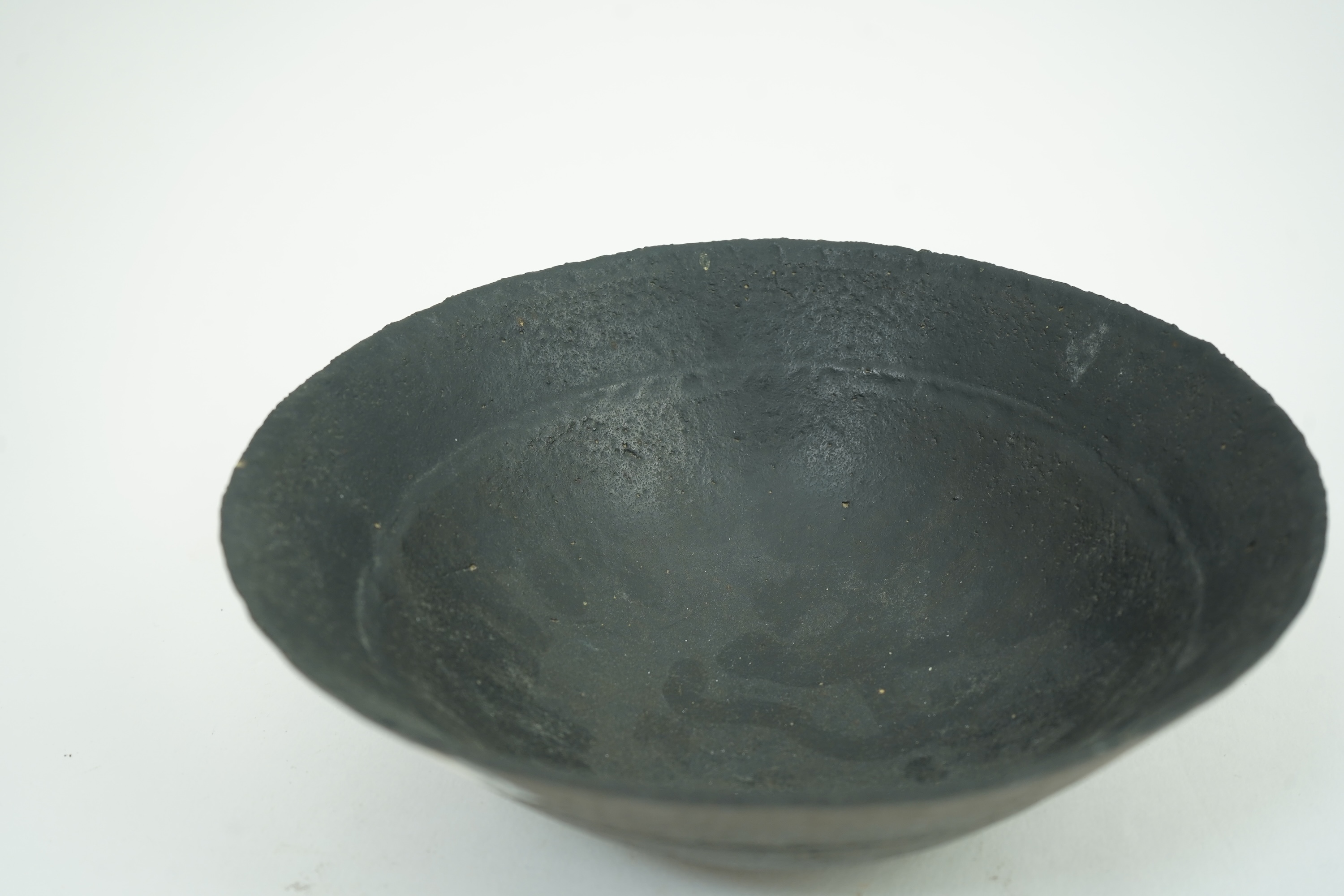 John Ward (1938-2023): A hand-built stoneware black glazed bowl with irregular rim